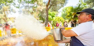 En la imagen, un momento en que unos de los "mestre paeller" de GALBIS lanza el arroz a la paella. Foto: Kike Ayala (Rivas Actual).