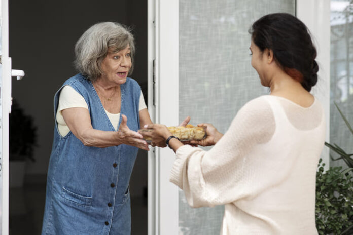 mujer-ofreciendo-comida-al-vecino